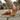 Ease barefoot slip on shoe in caramel brown, worn side view on cobblestone with gum sole