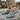 Breeze barefoot sneaker in grey worn on a stone path, side view