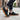 Pulse barefoot sneaker in black with gum sole, worn walking a city street, side view