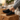 Pulse barefoot sneaker in black with gum sole, worn with feet up on a wood block indoors, side view