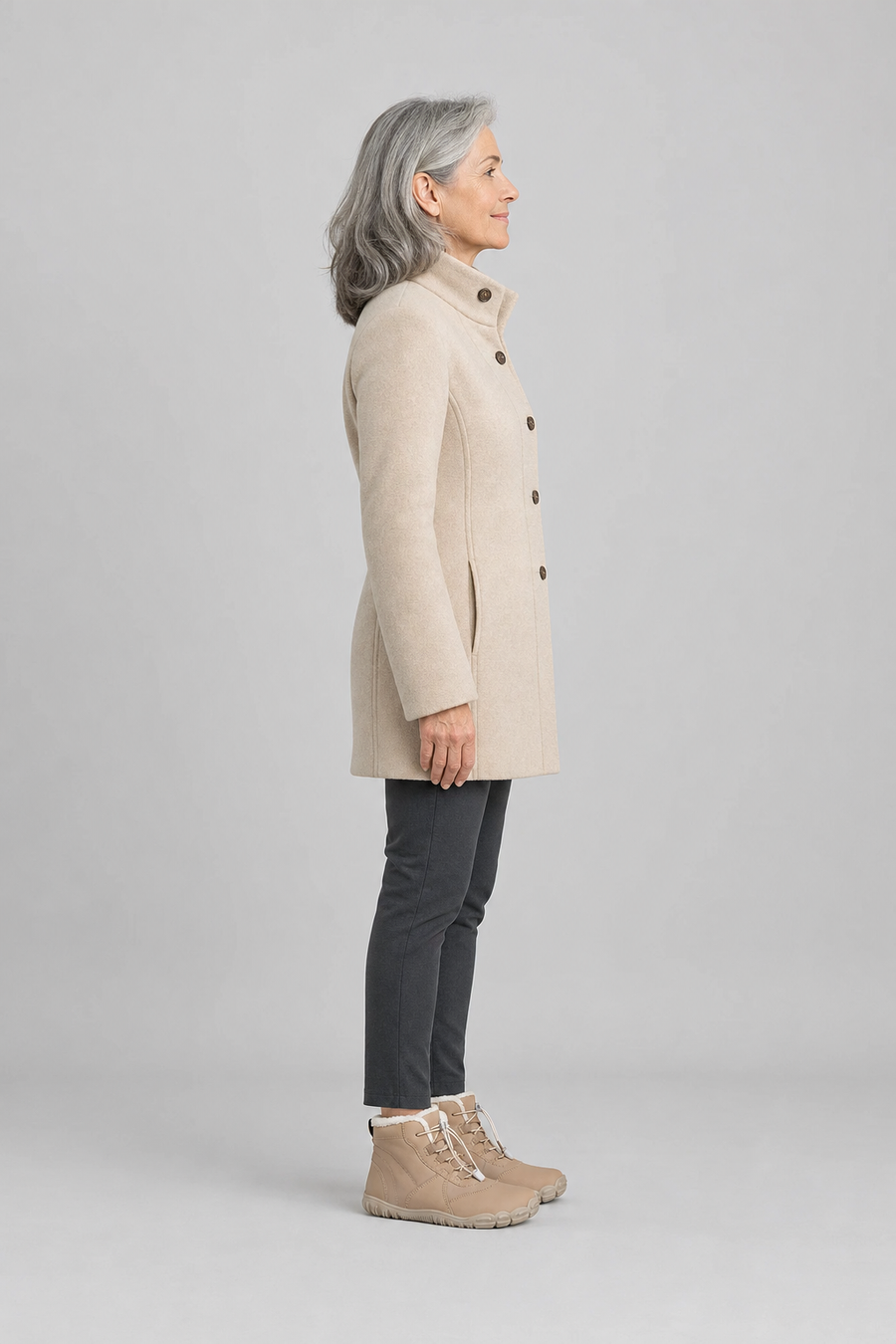 A woman standing in the Emberfield boots, side view showing her hips, knees, ankles and the ball of her foot