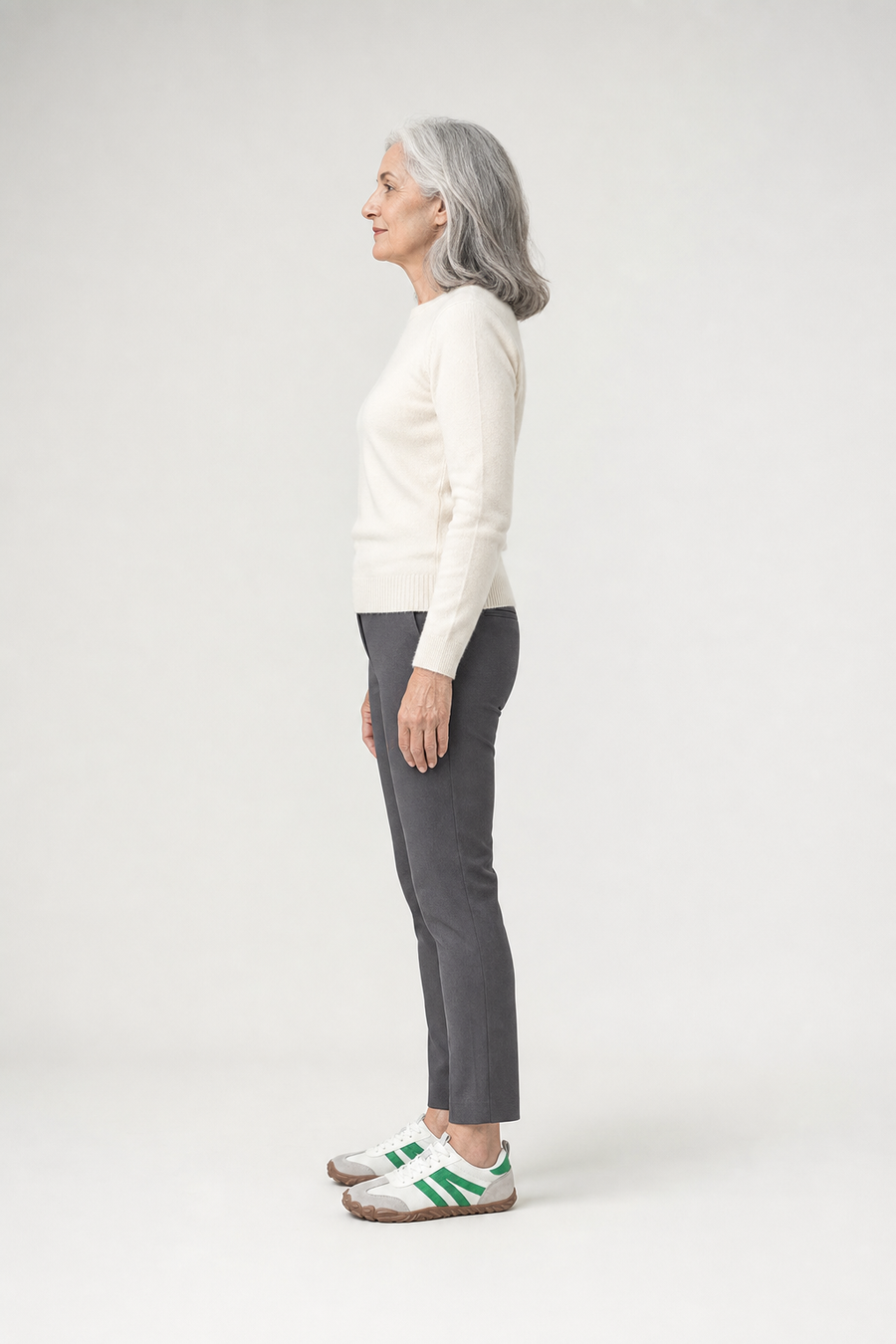 A woman standing in the Field shoes, side view showing her hips, knees, ankles and the ball of her foot