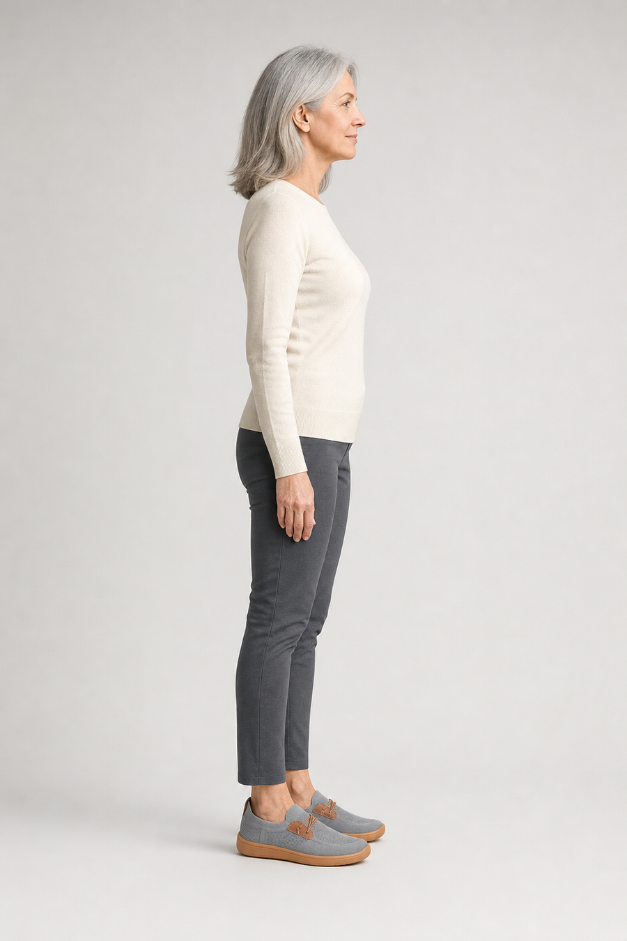 A woman standing in the Loafers, side view showing her hips, knees, ankles and the ball of her foot
