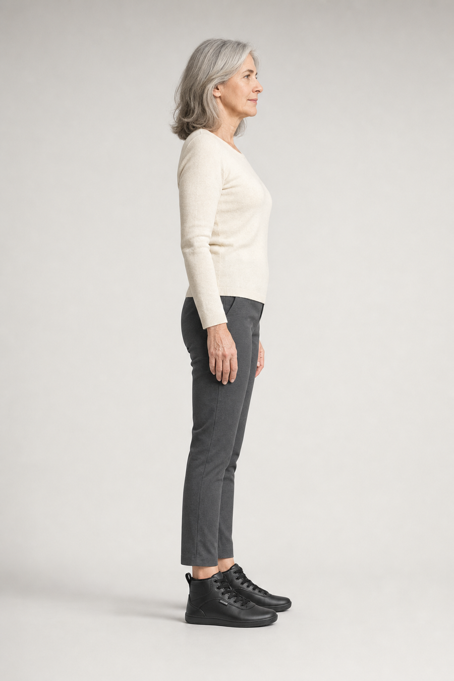 A woman standing in the Meadow shoes, side view showing her hips, knees, ankles and the ball of her foot