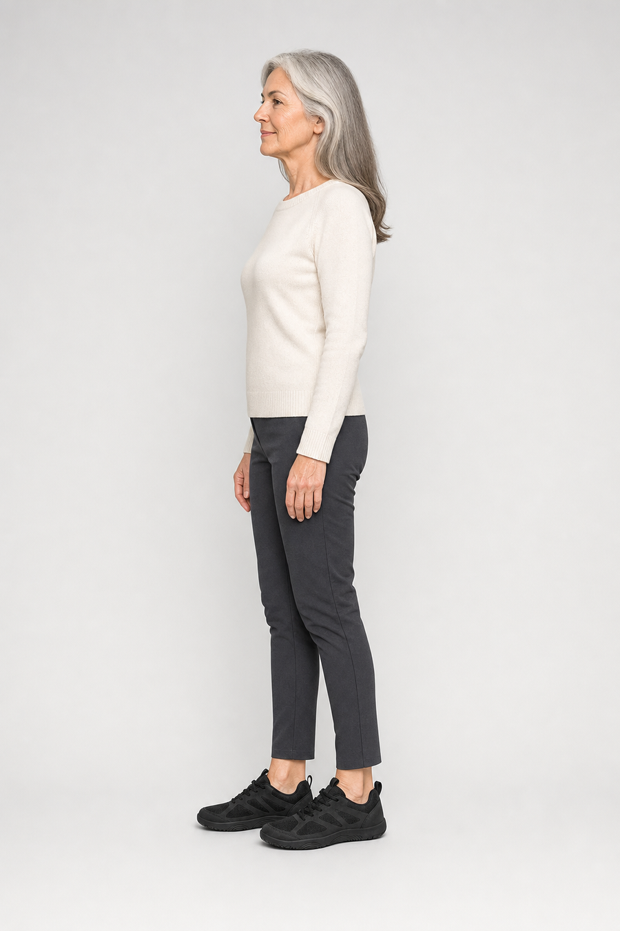 A woman standing in the Pace shoes, side view showing her hips, knees, ankles and the ball of her foot