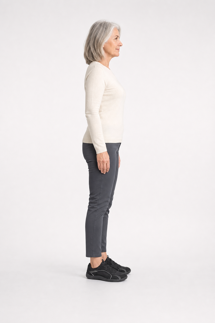 A woman standing in the Ridge shoes, side view showing her hips, knees, ankles and the ball of her foot