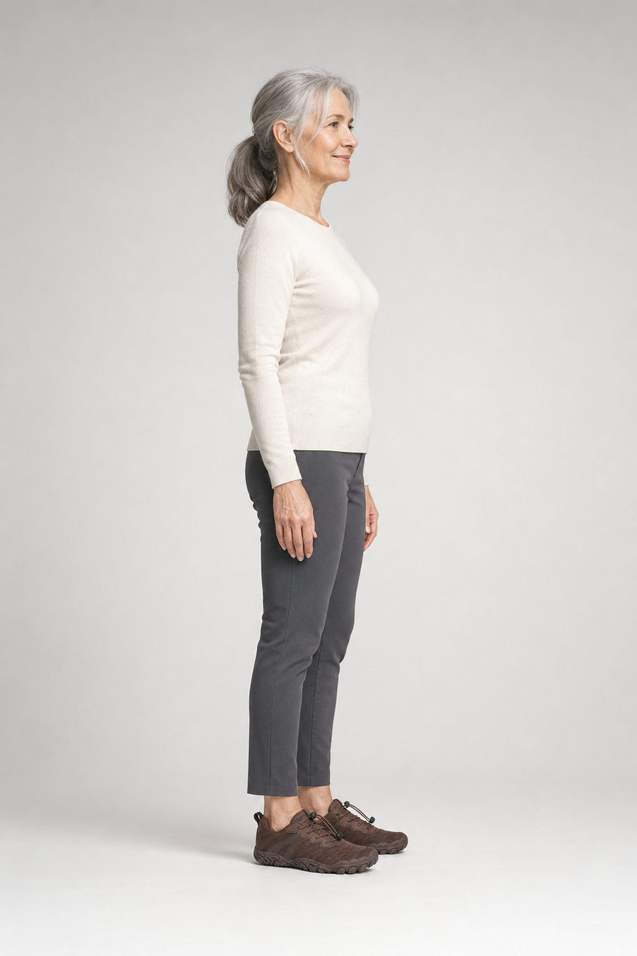 A woman standing in the Summit shoes, side view showing her hips, knees, ankles and the ball of her foot