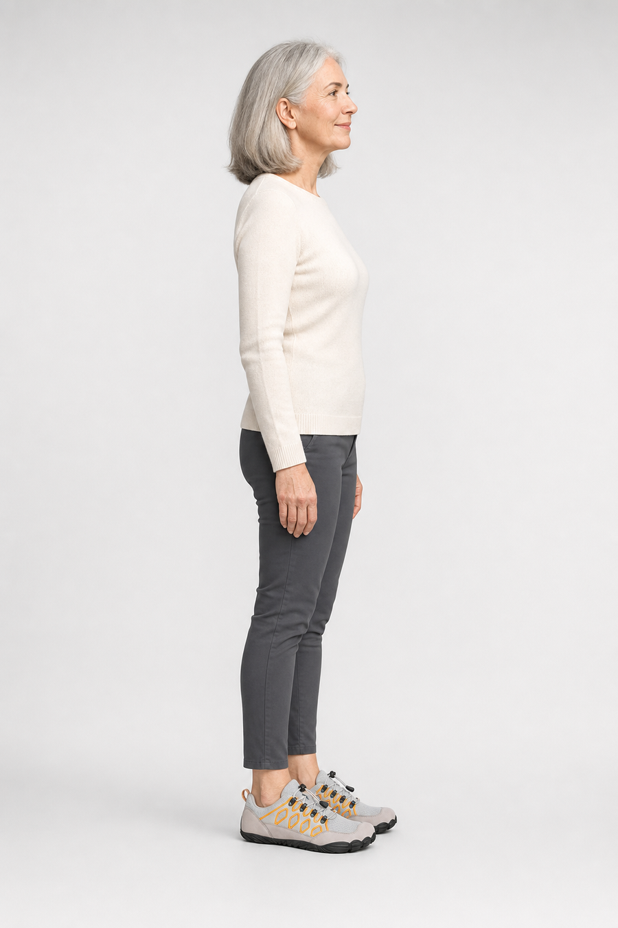 A woman standing in the Trailblazer shoes, side view showing her hips, knees, ankles and the ball of her foot
