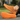 Ease barefoot slip on shoe for men in orange, worn seated with one shoe showing the outsole tread