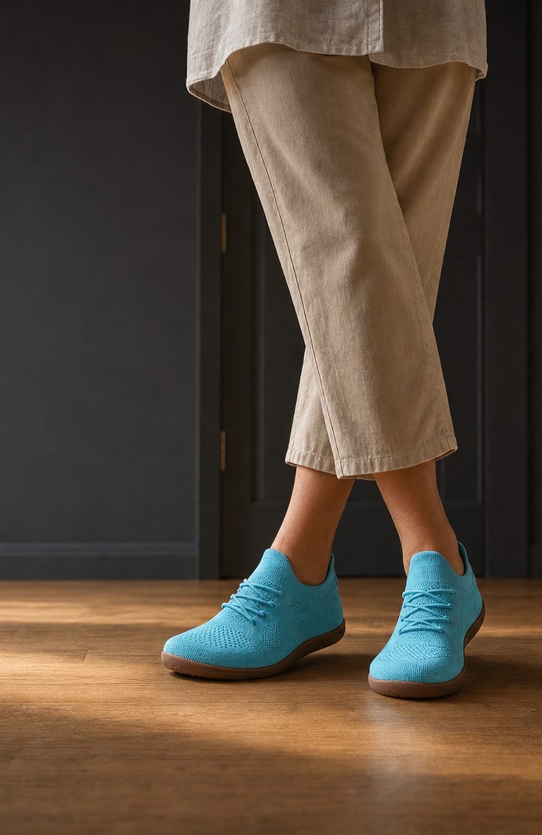 Woman by the front door wearing the Stride barefoot sneakers